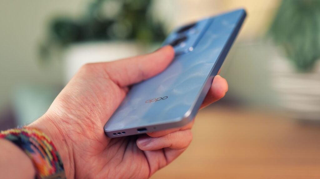 Oppo Reno 11F 5G in hand, showing the bottom